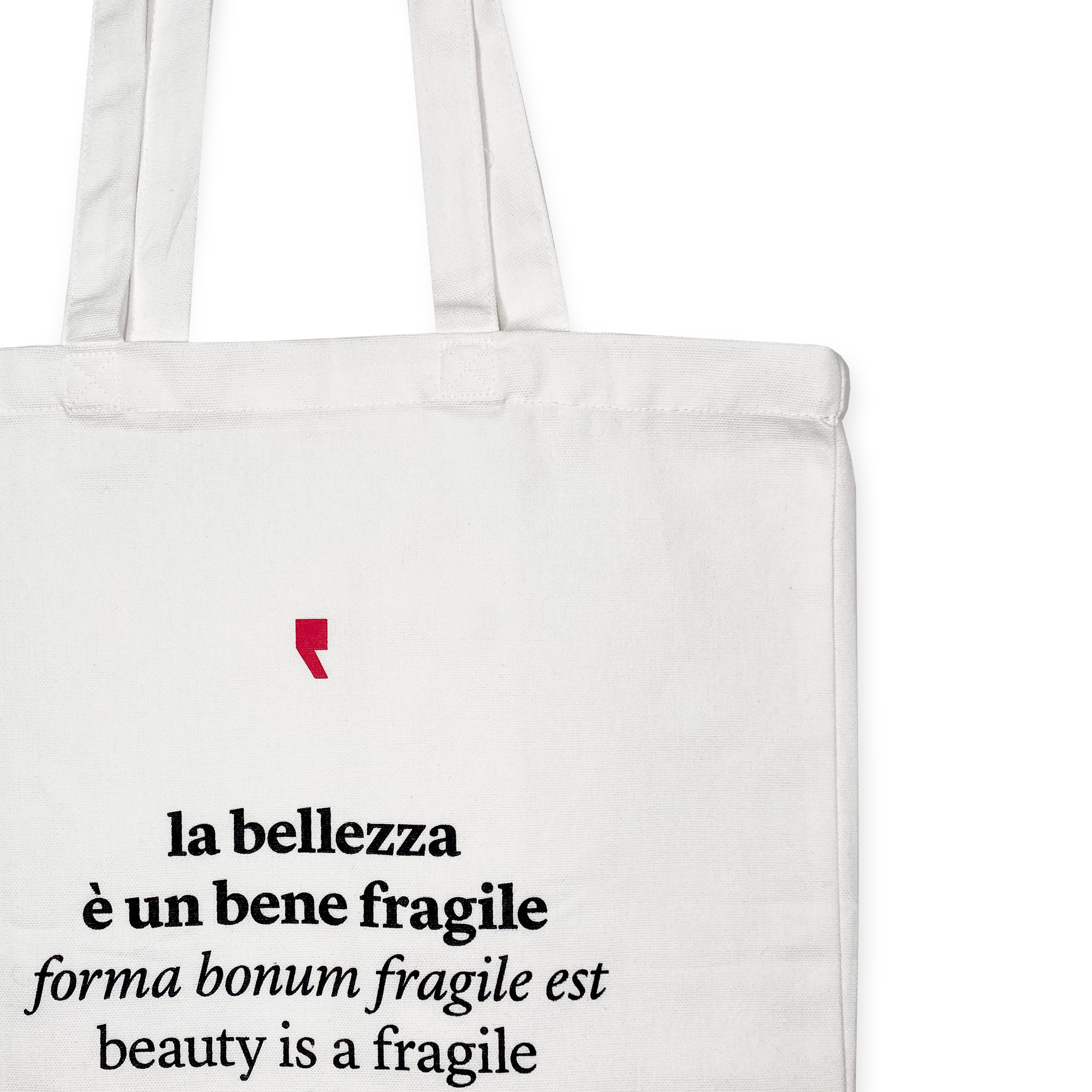 Dettaglio della frase “La bellezza è un bene fragile” stampata in nero su shopper bianca in cotone – citazione poetica di Ovidio